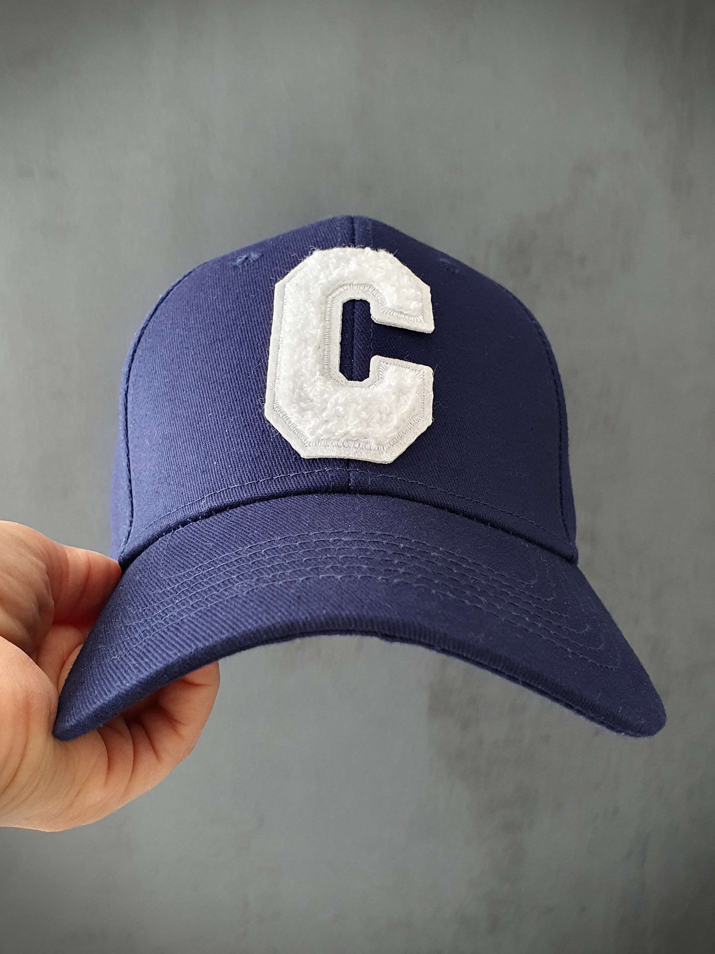 Découvrez notre casquette bleue marine tendance avec une lettre C en bouclette sur l'avant, ajoutant une touche d'originalité. Fabriquée à partir de 100% coton de qualité, cette casquette offre un confort optimal. Son design réglable à l'arrière permet un ajustement personnalisé pour s'adapter à toutes les tailles de tête. Que vous souhaitiez un look décontracté ou sportif, cette casquette polyvalente est un choix idéal. Complétez votre tenue avec style et profitez d'un accessoire pratique et à la mode.